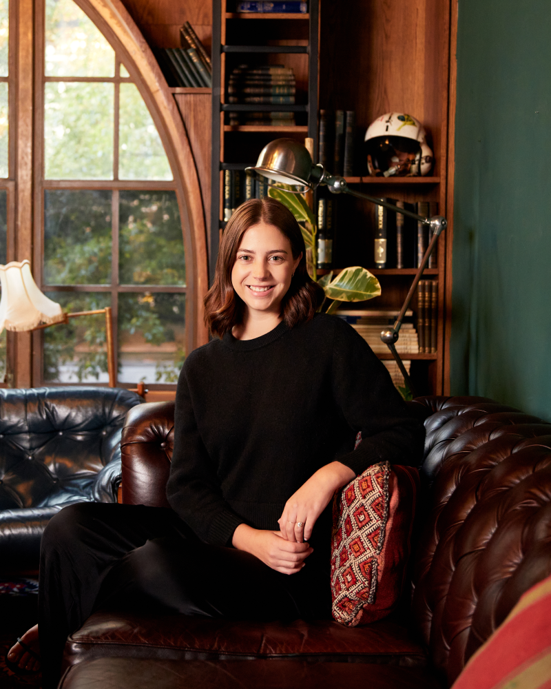 Smiling woman sitting on leather sofa.